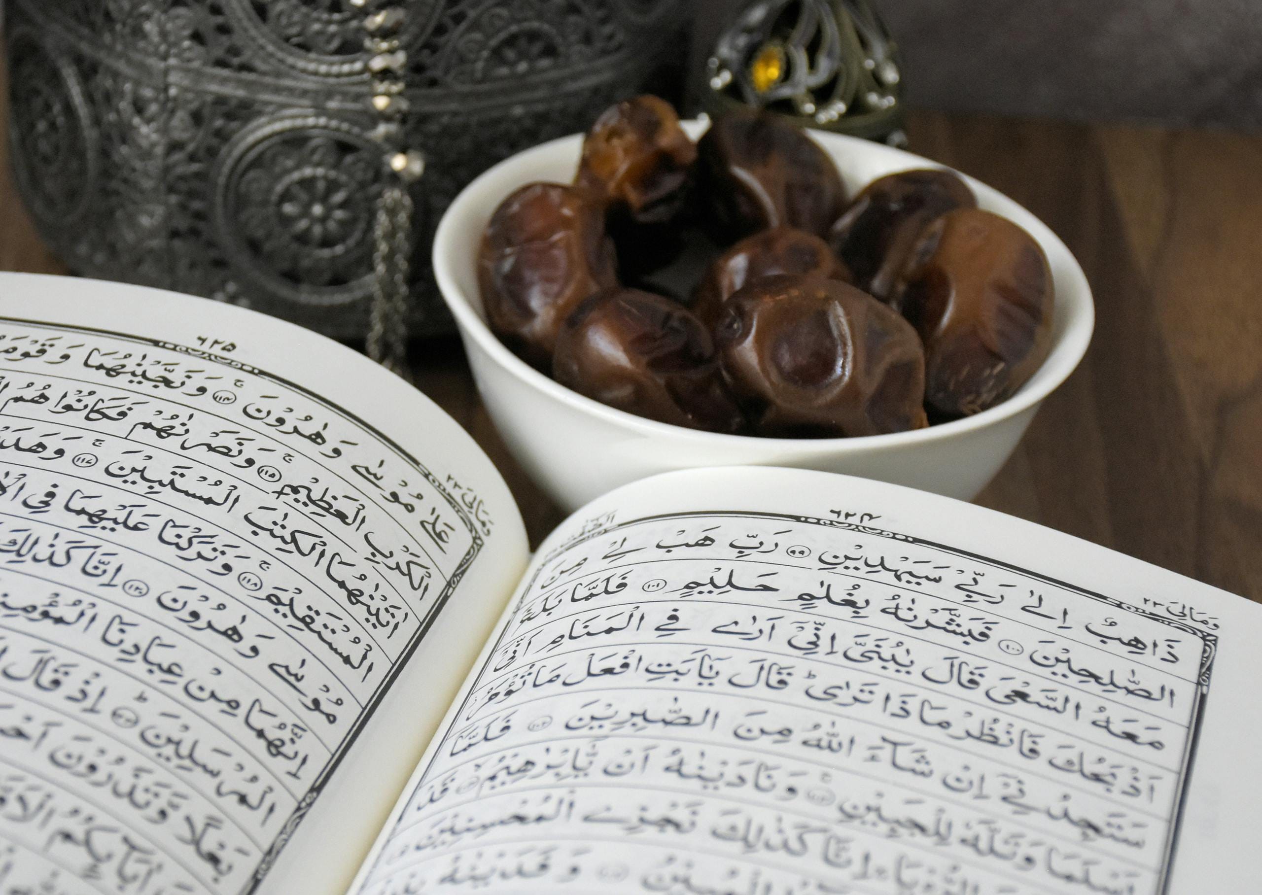 The Importance of Learning the Quran: A Complete Guide to Spiritual Growth 1 An open Quran with a bowl of dates, symbolizing Ramadan and Islamic traditions.