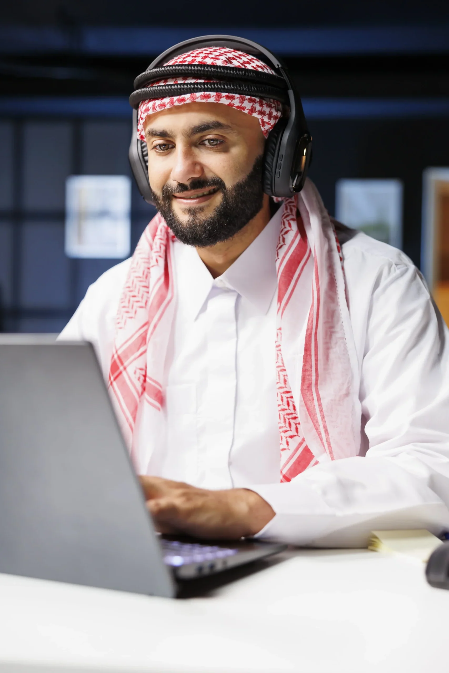 Man using laptop with headphones on.